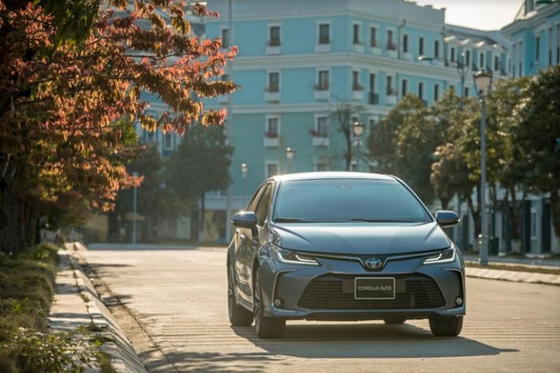 Một người lái xe máy điện nhập khẩu đang di chuyển trên đường phố Việt Nam hiện đại và sạch sẽ